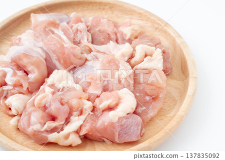 Raw chicken thigh pieces served on a wooden plate Raw chicken thigh pieces served on a wooden plate 137835092