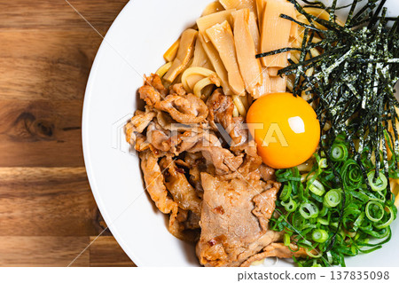 油拌麵配豬肉和生蛋；自製什錦麵，盛於木桌上。 137835098