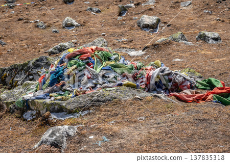 Old, tattered prayer flag debris on mountain in Langtang national park, Nepal. That should be treated with respect, as they are considered sacred, representing living prayers that have faded over time 137835318
