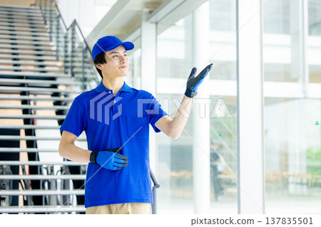 倉庫裡一名身穿藍色工作服的工人的照片 137835501