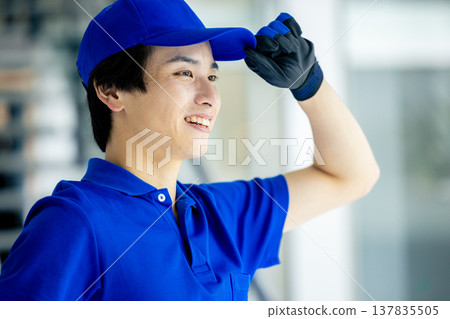 Image of a blue-clad worker in a warehouse Image of a blue-clad worker in a warehouse 137835505