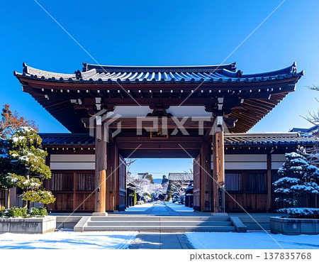 一座被白雪覆蓋的傳統日本寺廟大門，以及一片晴朗無雲的冬日景色。 137835768