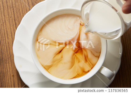 Adding milk to tea 137836565