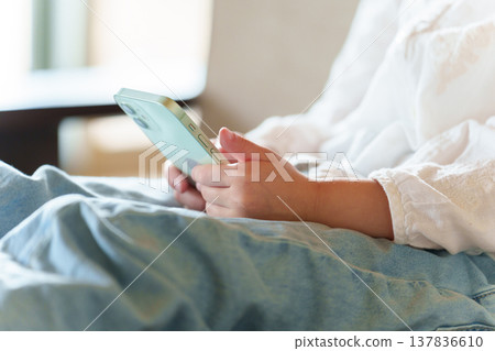 A girl's hands as she uses her smartphone A girl's hands as she uses her smartphone 137836610