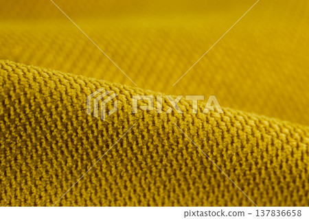Macro view of mustard yellow heavy-knit textile showing intricate loops and fiber depth Macro view of mustard yellow heavy-knit textile showing intricate loops and fiber depth 137836658