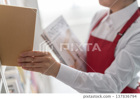 Bookstore staff picking up a magazine Bookstore staff picking up a magazine 137836794
