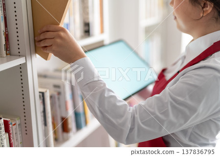 一位女店員拿著平板電腦和一本書 137836795