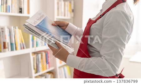 一位女店員拿起一本科學雜誌。 137836799