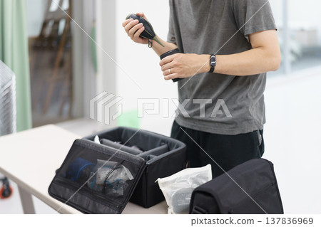 身穿T恤的人的上半身，正在室內準備拍照。 137836969