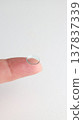A hard contact lens placed on the index finger. 137837339