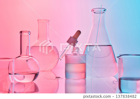 Scientific glassware with cosmetic serum and vibrant neon lighting 137838482