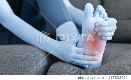 Asian woman standing and massaging her painful heel with red highlight. Heel spur, plantar fasciitis, Achilles tendonitis and foot injury concept for health care, physical therapy and medicine. Asian woman standing and massaging her painful heel with red highlight. Heel spur, plantar fasciitis, Achilles tendonitis and foot injury concept for health care, physical therapy and medicine. 137838811