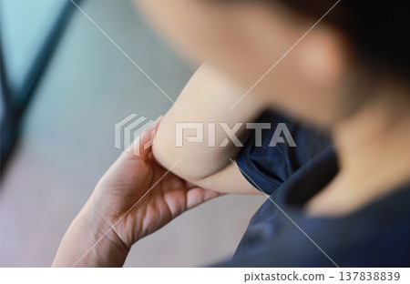 Close up of woman massaging her painful elbow with red highlight. Tennis elbow, bursitis, joint inflammation and muscle strain concept for health care, physical therapy and medical treatment. Close up of woman massaging her painful elbow with red highlight. Tennis elbow, bursitis, joint inflammation and muscle strain concept for health care, physical therapy and medical treatment. 137838839