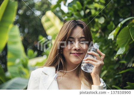 Young Woman Drinking Water bottle outdoor park traveler. Asian female drinking water bottle healthy person happy smile. Happiness Beautiful asian chinese women holding mineral water bottle lifestyle 137838900