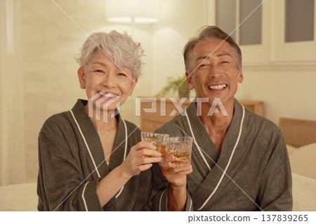 Senior couple drinking whiskey in the bedroom, portrait, looking at camera 137839265