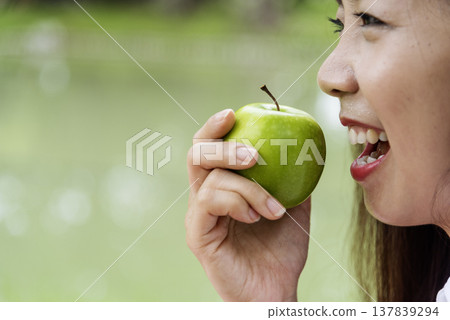 young asian woman eating Apple Healthy. Girl workout holding organic apple fruit healthy lifestyle. Wellness Asian women eat red apple smile face look at camera. Beauty health care lifestyle concept young asian woman eating Apple Healthy. Girl workout holding organic apple fruit healthy lifestyle. Wellness Asian women eat red apple smile face look at camera. Beauty health care lifestyle concept 137839294