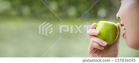 Banner young asian woman bite green Apple Healthy. Girl workout holding organic apple fruit healthy lifestyle. Banner close up women hands holding green apple. Women dieting lifestyle with copy space Banner young asian woman bite green Apple Healthy. Girl workout holding organic apple fruit healthy lifestyle. Banner close up women hands holding green apple. Women dieting lifestyle with copy space 137839295