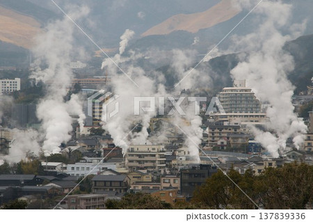 Steam rising from Kannawa Onsen and the hot spring town on a rainy day in March. 137839336