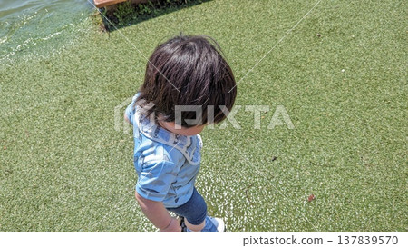 Boy playing by the water Boy playing by the water 137839570