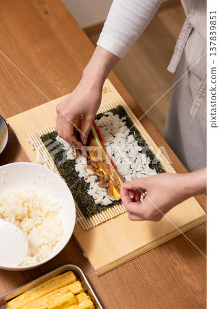 特寫:一位女士的手正在製作江方捲(吉利方向壽司捲)。 特寫:一位女士的手正在製作江方捲(吉利方向壽司捲)。 137839851