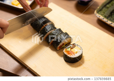 特寫:一位女士的手正在製作江方捲(吉利方向壽司捲)。 特寫:一位女士的手正在製作江方捲(吉利方向壽司捲)。 137839885