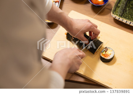 特寫:一位女士的手正在製作江方捲(吉利方向壽司捲)。 特寫:一位女士的手正在製作江方捲(吉利方向壽司捲)。 137839891