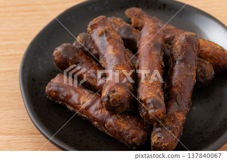 一盤黑色的油炸麵團小吃 137840067