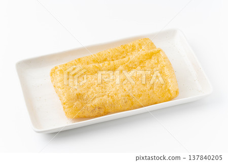 Deep-fried tofu on a plate against a white background. Deep-fried tofu on a plate against a white background. 137840205