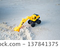 A sandy beach and a toy excavator 137841375
