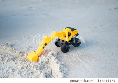 A sandy beach and a toy excavator A sandy beach and a toy excavator 137841375