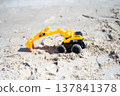 A sandy beach and a toy excavator 137841378