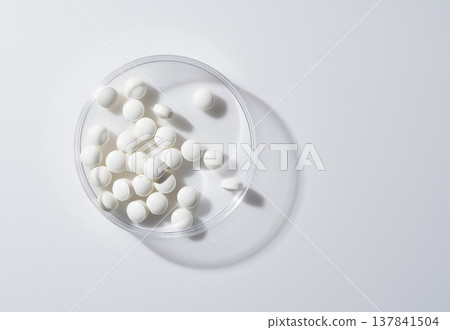 White tablets in a petri dish and copy space on the right. 137841504