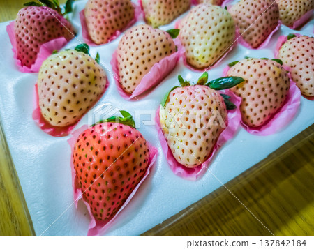 Close-up view of fresh, ready-to-eat, special variety of white and pink strawberries in a protective box. 137842184