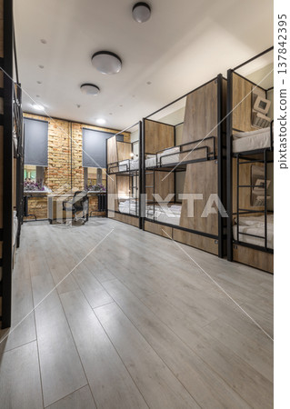 Modern Hostel Dormitory with Row of Bunk Beds and Workspace Modern Hostel Dormitory with Row of Bunk Beds and Workspace 137842395