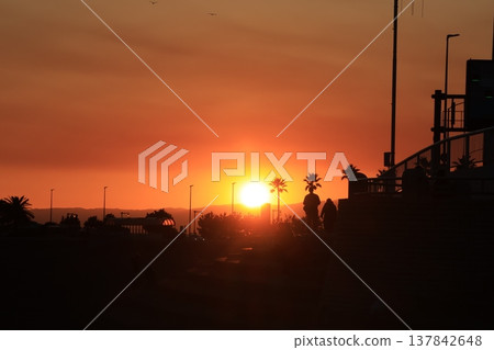 The scenery around Enoshima Island, bathed in orange light as seen from Koshigoe Beach at sunset. The scenery around Enoshima Island, bathed in orange light as seen from Koshigoe Beach at sunset. 137842648
