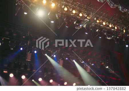 Professional Stage Lighting Rig with Multi-Color Spotlights in Dark with copy space 137842882
