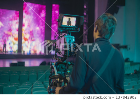 Professional Cameraman with Broadcast Camera in Large Concert Hall with Copy Space 137842902