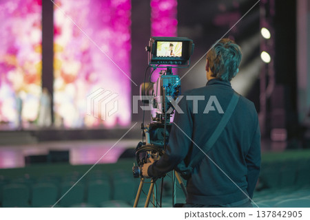 Professional Broadcast Cameraman Filming Live Show in Concert Hall with Copy Space Professional Broadcast Cameraman Filming Live Show in Concert Hall with Copy Space 137842905