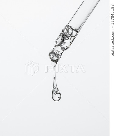 Long Serum Drop Hanging From Pipette Long Serum Drop Hanging From Pipette 137843188