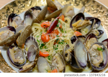 Authentic Vongole Bianco with plenty of clams and tomatoes - an image of lunch at an Italian restaurant. Authentic Vongole Bianco with plenty of clams and tomatoes - an image of lunch at an Italian restaurant. 137843216