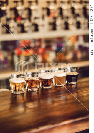 Various Craft Beers Showcased in Tasting Set on Wooden Bar Counter at Brewery 137843254