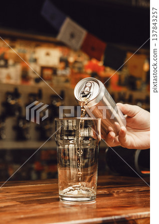 Pouring Cold Beer From an Aluminum Can Into Clear Glass Pouring Cold Beer From an Aluminum Can Into Clear Glass 137843257