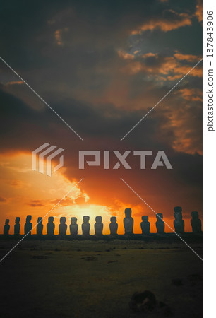Ancient Moai statues silhouettes at Ahu Tongariki sunset on Easter Island with copy space Ancient Moai statues silhouettes at Ahu Tongariki sunset on Easter Island with copy space 137843906