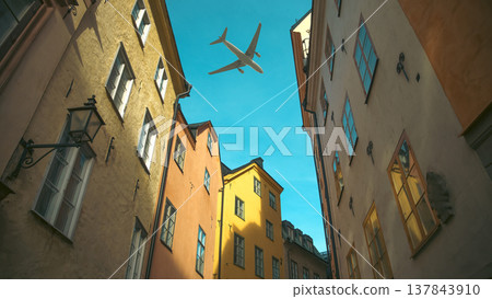 Airplane flying over colorful narrow street in Stockholm Gamla Stan with copy space Airplane flying over colorful narrow street in Stockholm Gamla Stan with copy space 137843910
