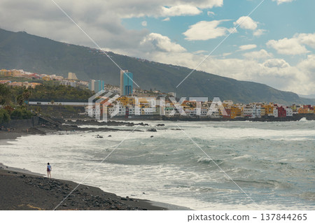 Solitary Person on Black Sand Volcanic Beach in Puerto de la Cruz Tenerife with copy space 137844265