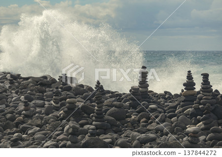 Balanced Zen Stones Cairns on Beach with Powerful Crashing Ocean Wave and Copy Space 137844272