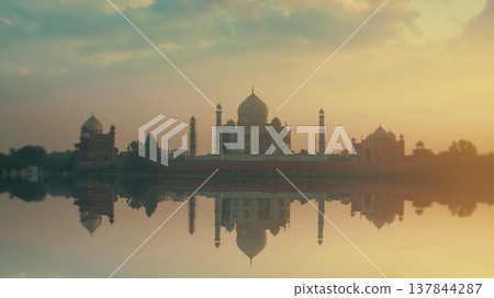 Taj Mahal reflected in Yamuna river at golden sunrise with copy space 137844287