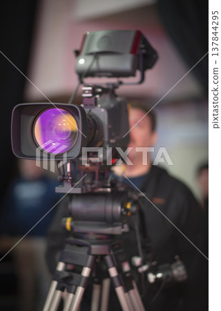 Professional video camera in modern news studio with pink lens flare and copy space Professional video camera in modern news studio with pink lens flare and copy space 137844295
