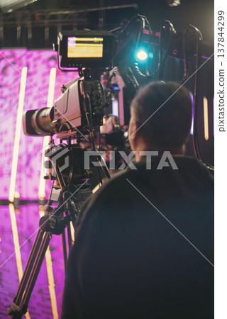 Professional cameraman in news studio with broadcast camera and copy space Professional cameraman in news studio with broadcast camera and copy space 137844299