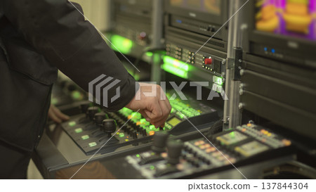 Professional engineer hand on video switcher control panel in news studio with copy space 137844304